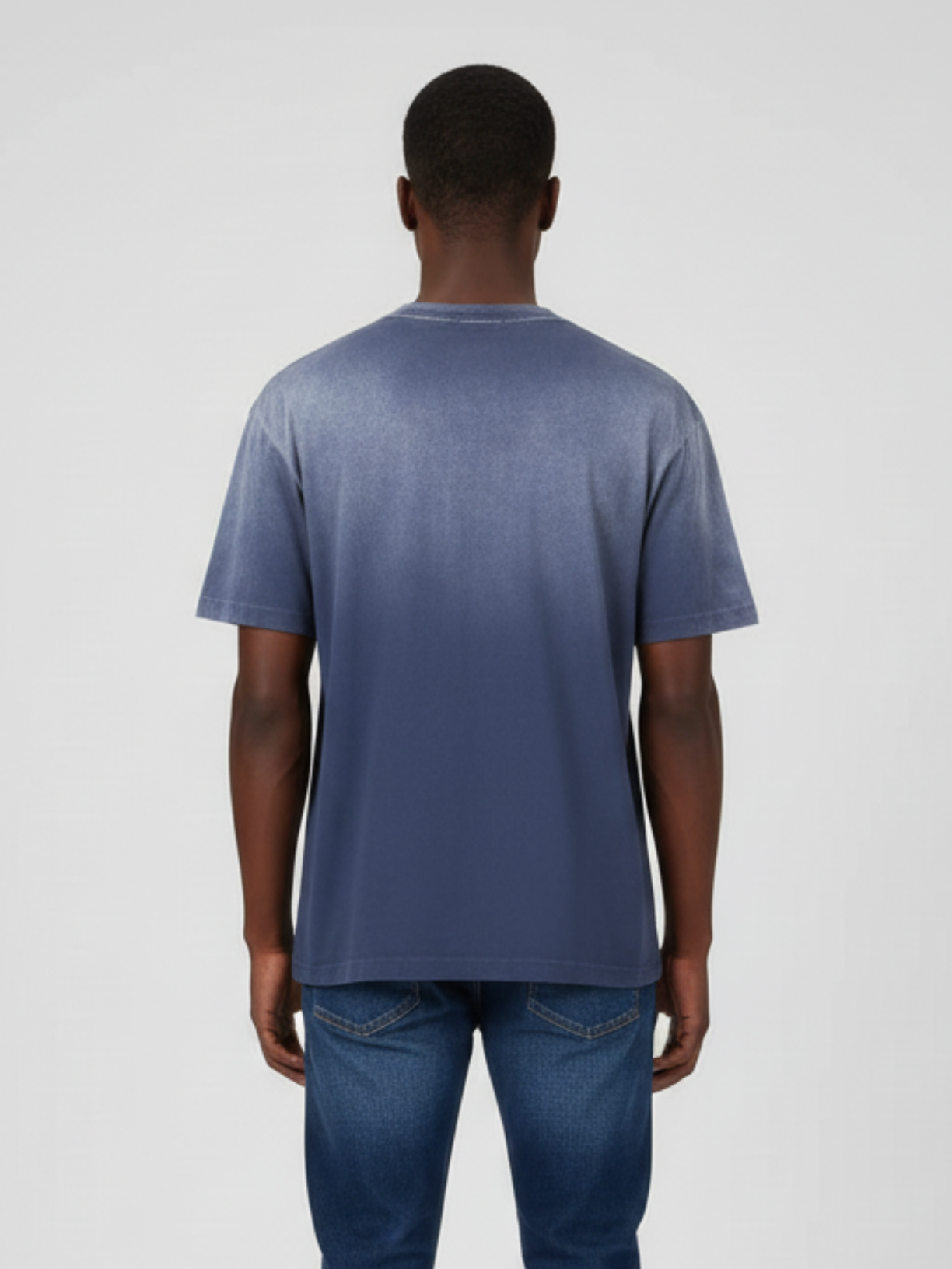 Person wearing a blue t-shirt and jeans on a plain background