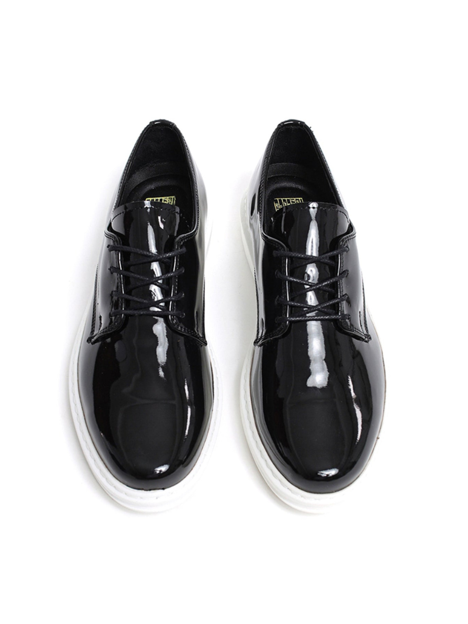 Black patent leather shoes on a white background