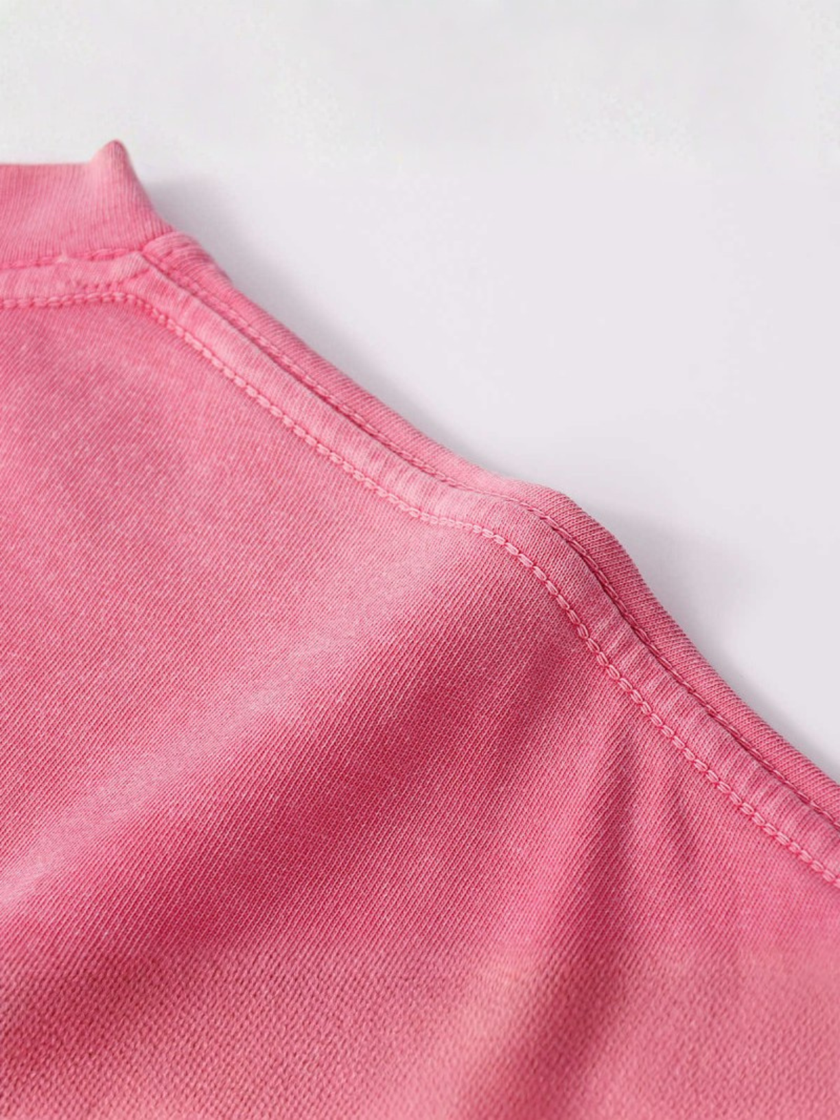 Close-up of a pink fabric texture on a light gray background