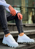 White sneakers with thick soles worn by a person on steps.