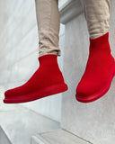 Lifestyle shot of Torino X Red ankle sock boots by Apollo Moda in bold red knit worn with casual outfit.